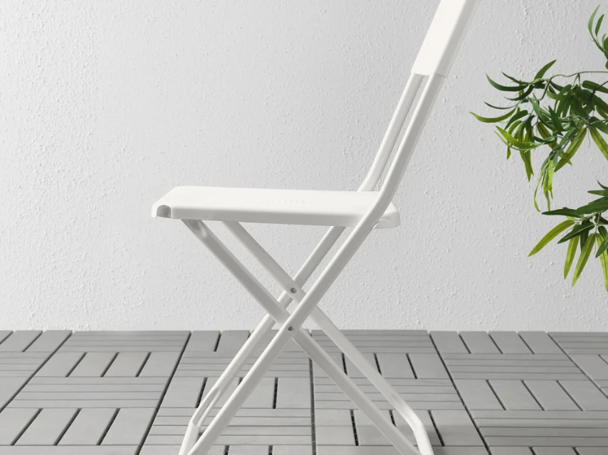 White outdoor folding chair on patio showing TiO2 masterbatch weather resistance
