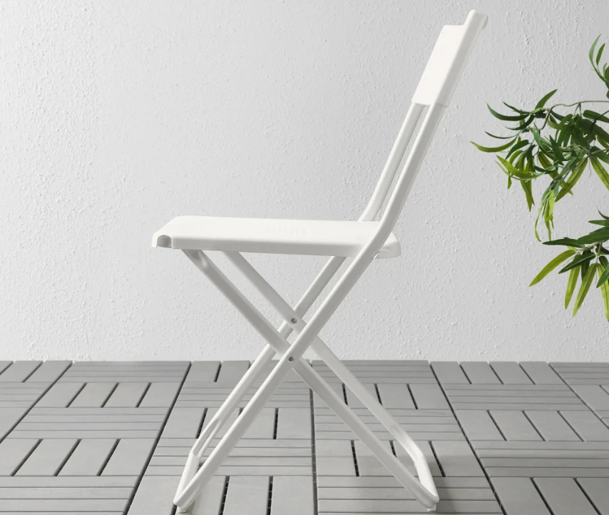 White outdoor folding chair on patio showing TiO2 masterbatch weather resistance