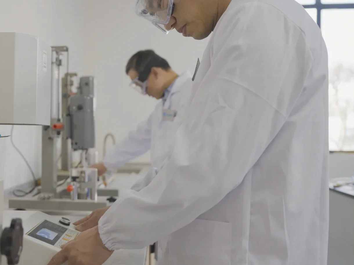 DEWOPP technicians performing melt flow index testing in the quality lab